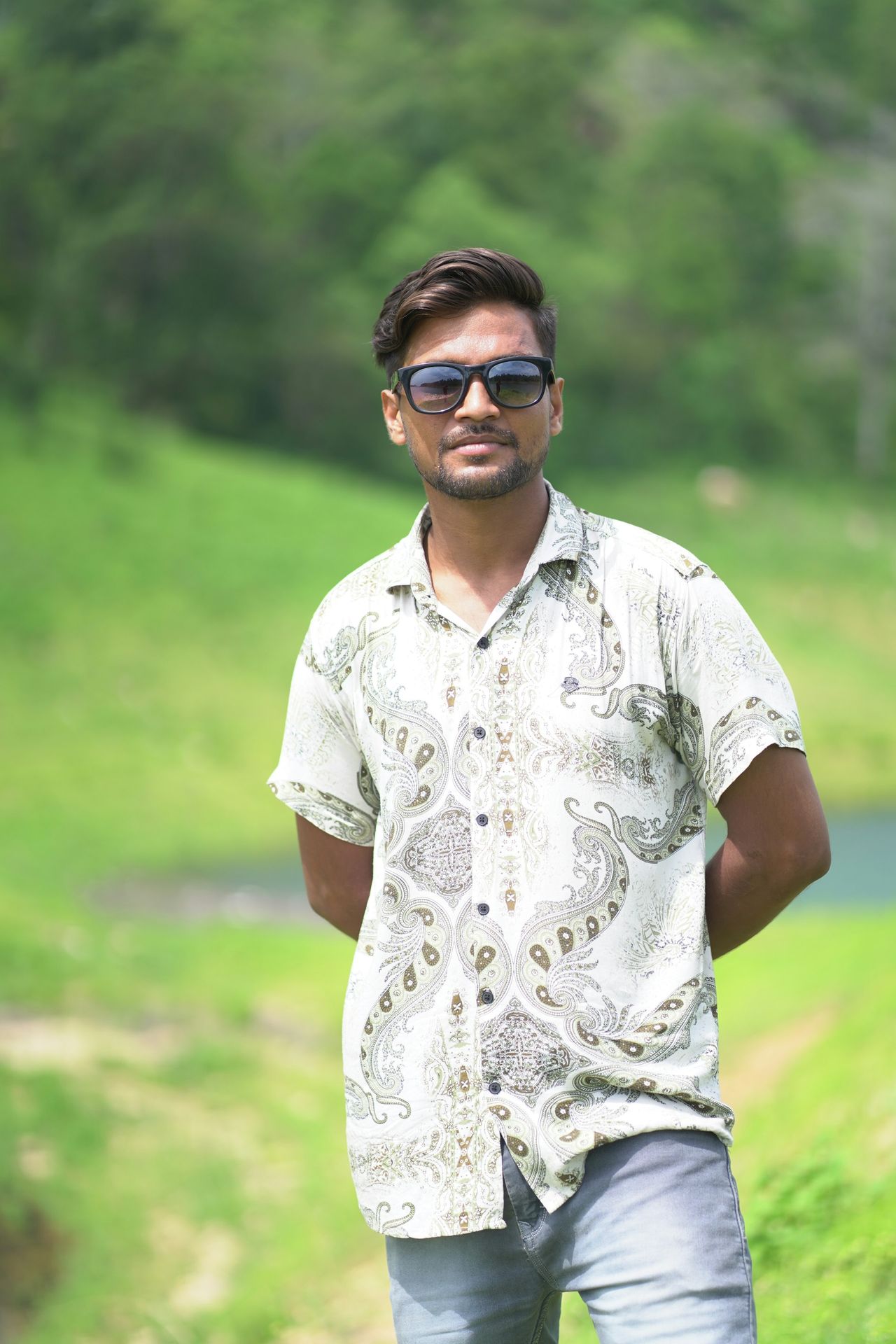 A man standing in a field with sunglasses on